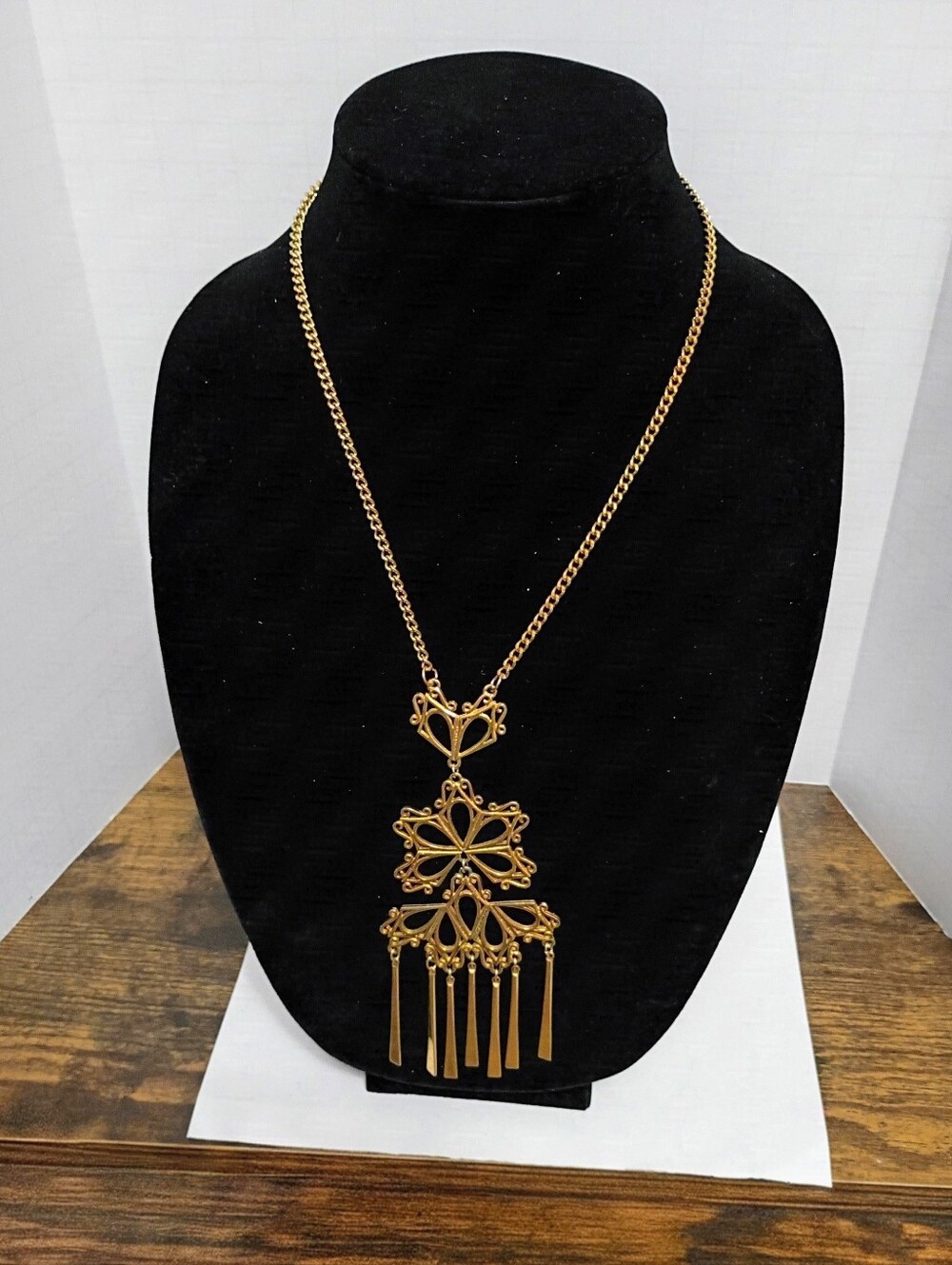 Gold pendant necklace with intricate floral and geometric design